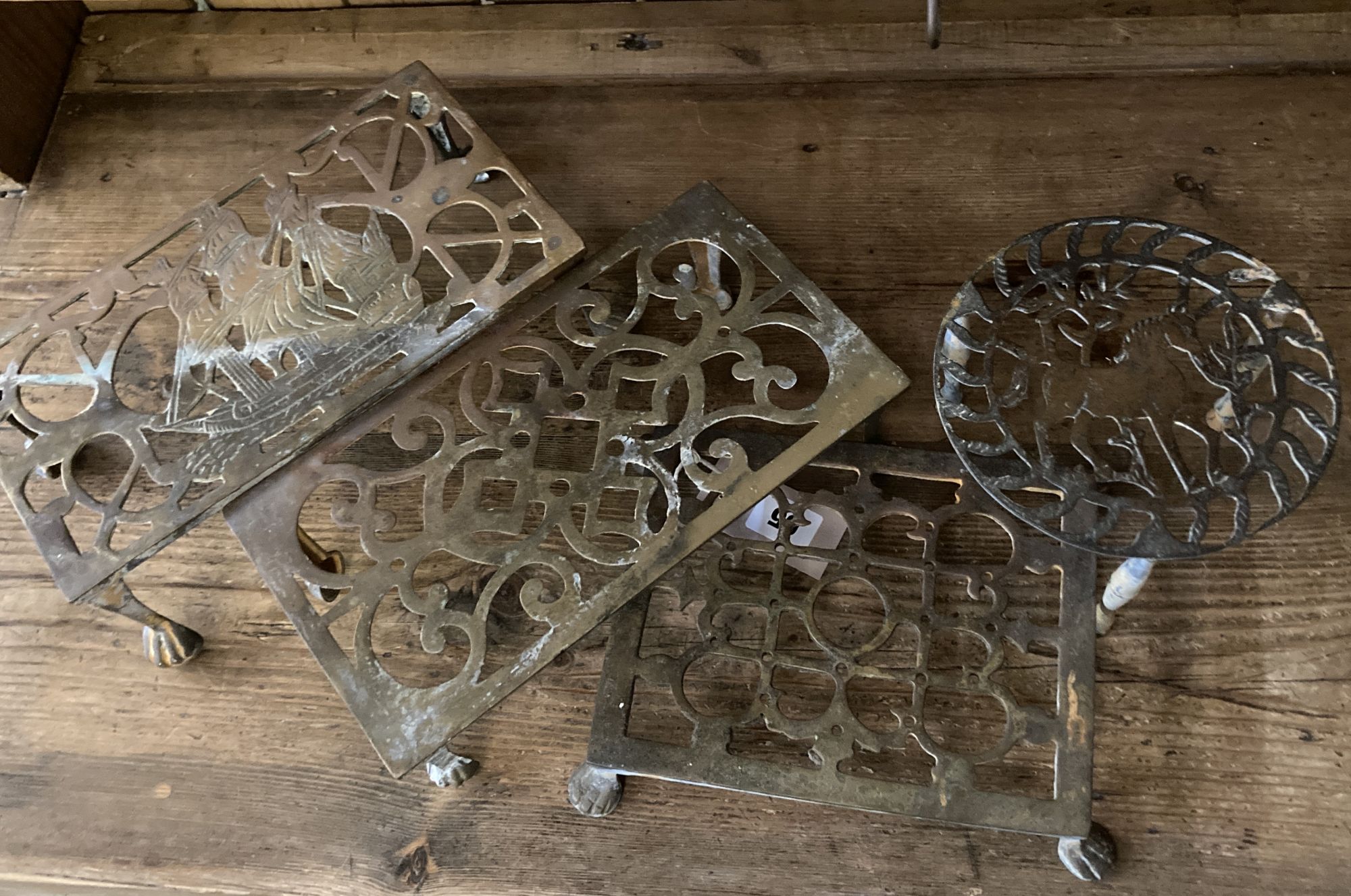 Five Victorian and later brass trivets, largest width 26cm, height 14cm